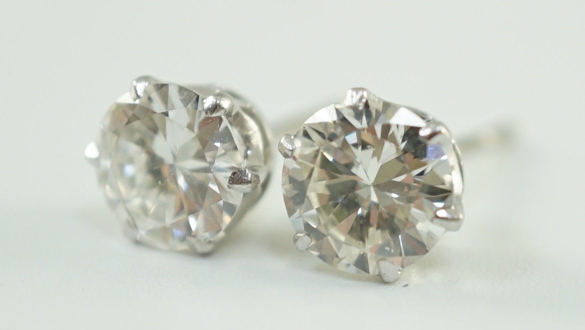 A pair of white gold and solitaire diamond set ear studs